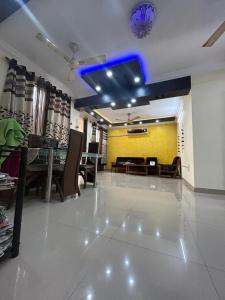 a living room with a table and a blue ceiling at rajul flats adarsh nagar jabalpur in Jabalpur
