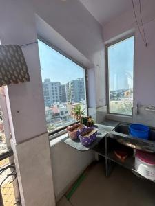a kitchen with a view of a city from a window at rajul flats adarsh nagar jabalpur in Jabalpur