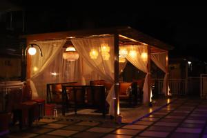einen Pavillon mit Stühlen und nachts Licht in der Unterkunft Kasar Himalaya Holiday Home, Binsar Rd in Almora