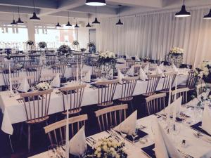 a large banquet hall with tables and chairs with flowers at Fugl Fønix Hotel in Etnesjøen
