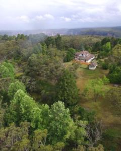 an aerial view of a house in the middle of a forest at Mount Booralee in Blackheath