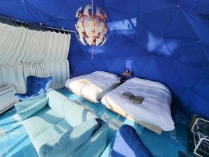 a blue room with two beds and chairs in it at -SORA-BASE（ソラベース） in Toyohama