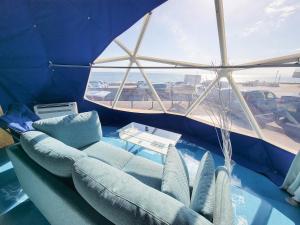 a living room with a couch and a large window at -SORA-BASE（ソラベース） in Toyohama