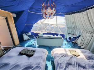 a room with two beds in a blue tent at -SORA-BASE（ソラベース） in Toyohama