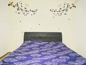 een slaapkamer met een bed met paarse lakens en een tak bij 彬彬流星瞭望台 The VenusBlock B 31st floor Sri Manjung in Seri Manjung