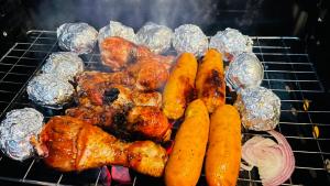 a group of chicken and vegetables on a grill at Almost Heaven in Talawakele