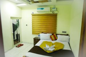 a bedroom with a bed with a yellow blanket at SILVER HOMES Service Apartments in Alwaye