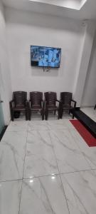 een wachtkamer met stoelen en een schilderij aan de muur bij Hotel StarLight By i line in Ujjain