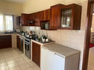 a kitchen with wooden cabinets and a counter top at AEROPARK RESIDENCIAL2 in Maputo
