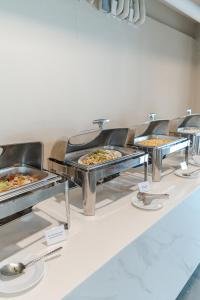 a buffet line with trays of pizzas on display at Best Western Chatuchak in Bangkok