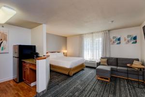 a hotel room with a bed and a couch at TownePlace Suites Denver Southwest/Littleton in Littleton