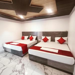 two beds with red pillows in a room at RUPALI GUEST HOUSE in Badrinath