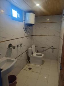 a bathroom with a toilet and a sink at RUPALI GUEST HOUSE in Badrinath