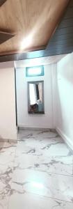 a room with a mirror and a white wall at RUPALI GUEST HOUSE in Badrinath