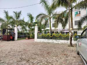 Pura RaghunāthHotel Dawat的楼前有棕榈树的围栏