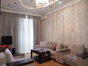 ein Wohnzimmer mit einem Sofa und einem TV in der Unterkunft My sweet home on Gadzhibekova 105-119 in Baku