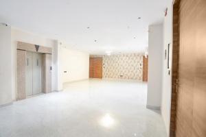 an empty hallway with white walls and white floors at FabHotel The Comfort Inn in Kānpur