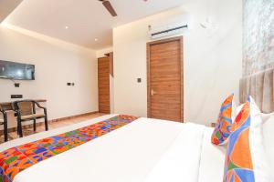a bedroom with a bed and a dining room at FabHotel The Comfort Inn in Kānpur