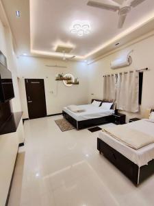 a bedroom with two beds and a television in it at DivineStay - Full Villa by AP Villas in Ujjain