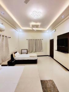 um quarto com uma cama e uma televisão de ecrã plano em DivineStay - Full Villa by AP Villas em Ujaim