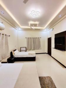 a bedroom with a bed and a flat screen tv at DivineStay - Full Villa by AP Villas in Ujjain