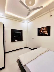 a bedroom with a bed and a ceiling fan at DivineStay - Full Villa by AP Villas in Ujjain
