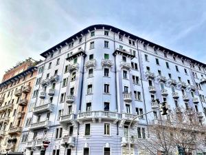 a large white building with balconies on top of it at Washington apartment in Milan