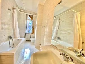 a white bathroom with a tub and a sink and a tubermott at Washington apartment in Milan