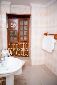 baño con lavabo y aseo y ventana en The Island Stone Town hotel, en Ngambo