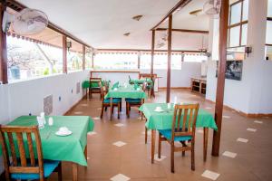 a restaurant with green tables and chairs in a room at The Island Stone Town hotel in Stone Town