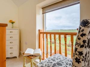 a bedroom with a window and a book on a chair at 1 Bed in Caunton 91130 in Caunton