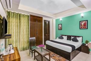 a hotel room with a bed and a table at OYO Townhouse 1055 Hotel Rumaisa in Indirapuram