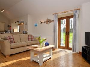 a living room with a couch and a table at 2 Bed in Bude CORYB in Morwenstow