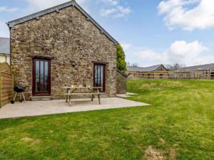 a stone building with a picnic table in a yard at 2 Bed in Holsworthy GMEAD in Sutcombe