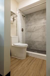 Exclusivo Inn and Suites Near Arlington Stadium في غراند براري: حمام مع مرحاض ودش