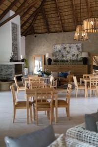 a dining room with wooden tables and chairs at Mologa River Lodge in Rust de Winter