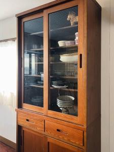 a wooden cabinet with glass doors in a room at ひねもす102:宇野駅から車で5分 直島へ 最大8名様 古民家 in Tamano