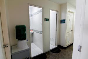 a bathroom with a shower and a toilet with a mirror at DG Budget Hotel Salem in Manila