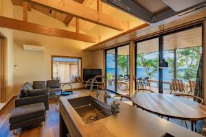 a kitchen and living room with a table and chairs at ガーデンヴィラ白浜　KOTI in Shimoda