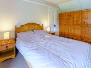 a bedroom with a large bed and wooden cabinets at 3 bed property in Swansea South Wales 83479 