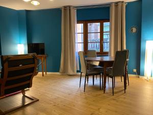 een eetkamer met een houten tafel en stoelen bij Laterale Residences Riquewihr in Riquewihr