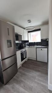 a large kitchen with white cabinets and a sink at NEW! Brand New Beautiful Modern Apartment in London