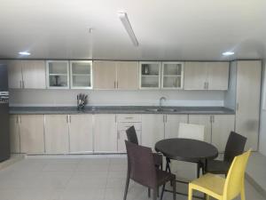 a kitchen with a table and chairs and a sink at Noor Farm Stay 5BHK in Khor Fakkan