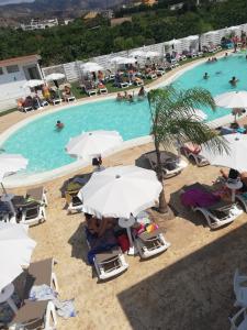 een uitzicht over een zwembad met stoelen en parasols bij All'Ombra Del Noce B&B in Catona