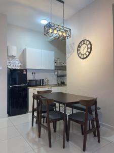 a kitchen with a table and chairs and a clock at DnQ Homestay at The Horizon with Netflix, LG Purifier,Wifi in the Centre of Ipoh in Ipoh