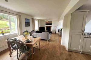 - un salon avec une table, des chaises et un canapé dans l'établissement ERIN NEAMH - Magnificent sea views cosy cottage in Cumbria, 