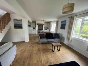 a living room with a couch and a table at ERIN NEAMH - Magnificent sea views cosy cottage in Cumbria 