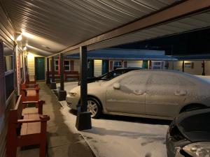 a car parked in a garage with snow on the ground at Tour Inn Motel in Howard City