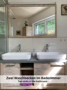 La salle de bains est pourvue de 2 lavabos et d'un miroir. dans l'établissement Apartments Viola Altenmarkt, à Altenmarkt im Pongau