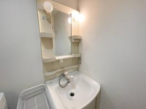 a white bathroom with a sink and a mirror at TasoneStayOsaka なんば大国大山302 in Osaka